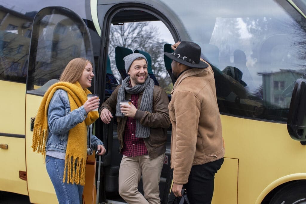 Group of friends boarding a coach in winter clothes.